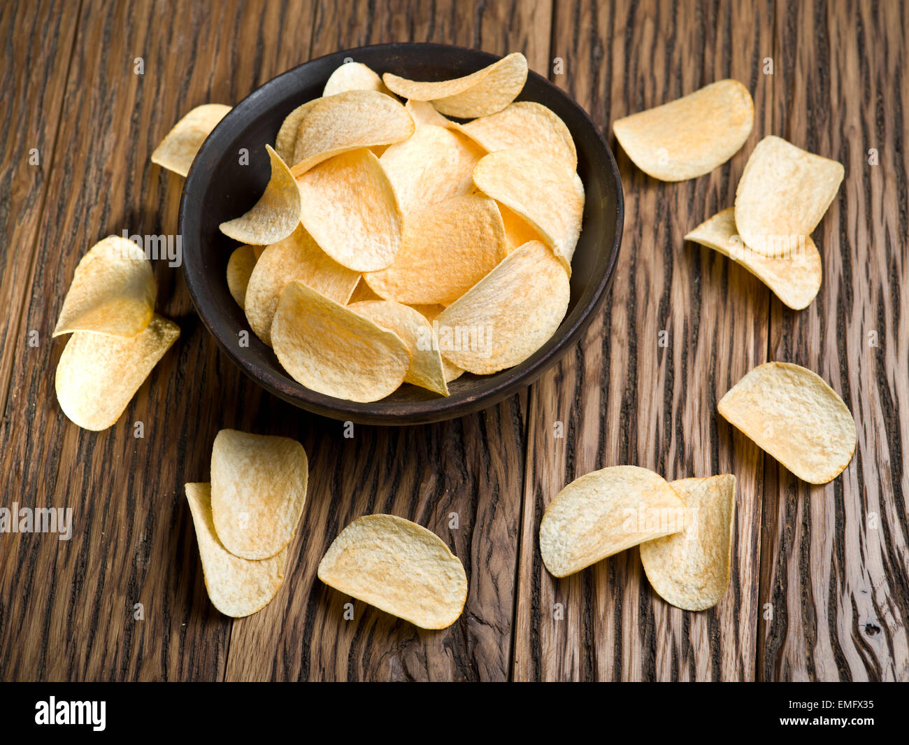 Kartoffel-Chips auf einem hölzernen Hintergrund. Stockfoto