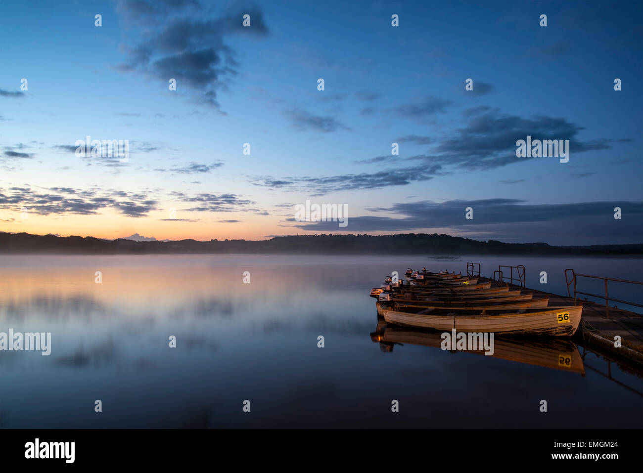 Landschaft-Sonnenaufgang über dem noch See mit Booten auf Steg Stockfoto