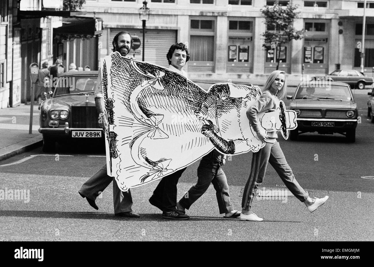 Comedy Schauspieler John Cleese mit Not The Nine O Clock News Darsteller Rowan Atkinson und Pamela Stephenson tragen eine aus, schneiden Sie mit Hilfe von 3ft 10 in Schauspieler David Rappaport, wie sie ihre neue show "The Secret Policeman es Other Ball" auf der Straße. 6. September 1981. Stockfoto