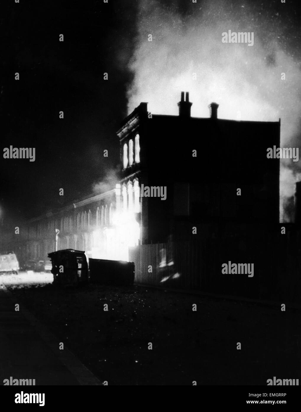 Fahrzeuge liegen auf ihrer Seite in den ausgebrannten Straßen von Brixton ausgebrannt, wie Gebäude nach einer Nacht der Ausschreitungen in Südlondon blaze. 11. April 1981. Stockfoto