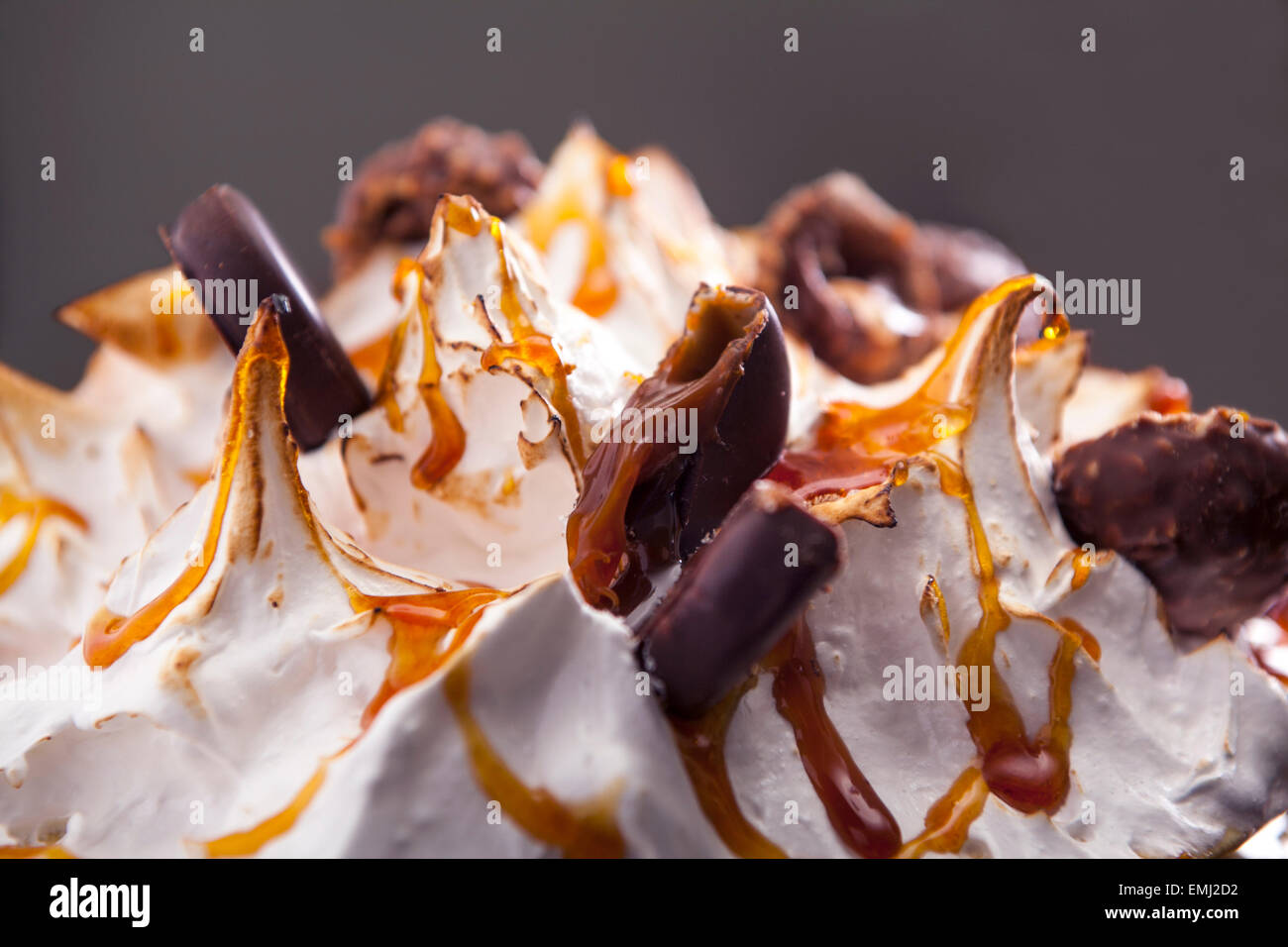 Closeup-Baiser-Kuchen mit Schokolade, Karamell und Pralinen Stockfoto