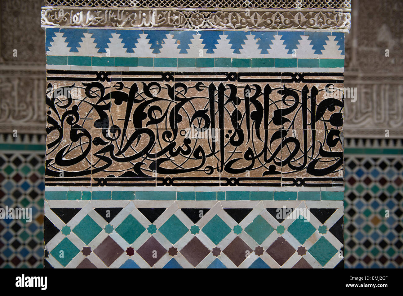 Al Attarine Madrasa, Koranschule, in Fes, Marokko.  Detail von arabischer Schrift geschnitzt in Fliese, höchste Form der Kunst in Koranschulen Stockfoto