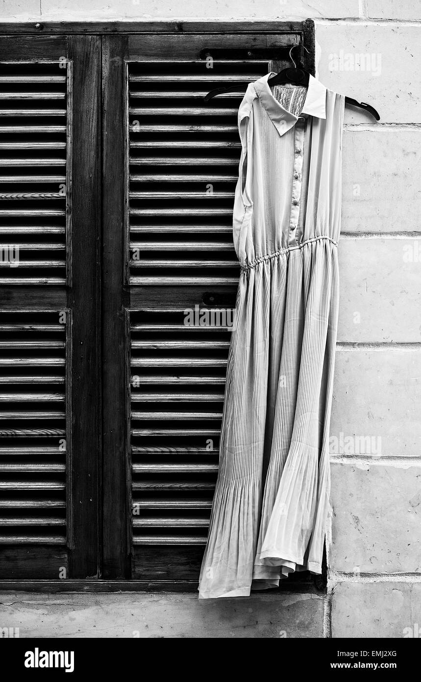 Altes Kleid in einem Fenster in schwarz / weiß Foto, konzeptionelle Foto der alten Kleid, Vintage-Foto, Vintage Kleid verloren auf der Straße Stockfoto