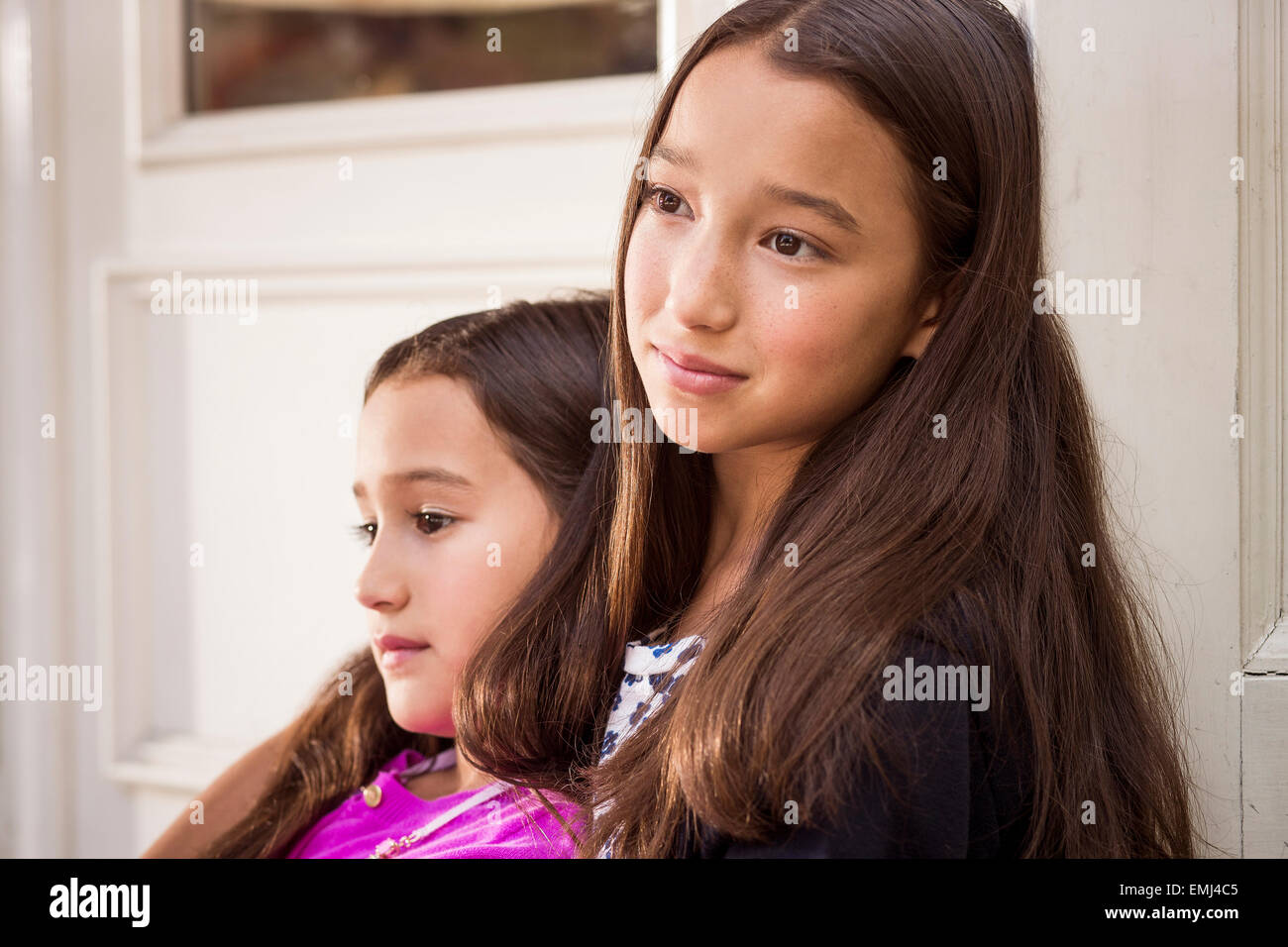 Porträt von zwei jungen Mädchen mit jüngeren Mädchen lehnte sich gegen ältere Mädchen, close-up Stockfoto
