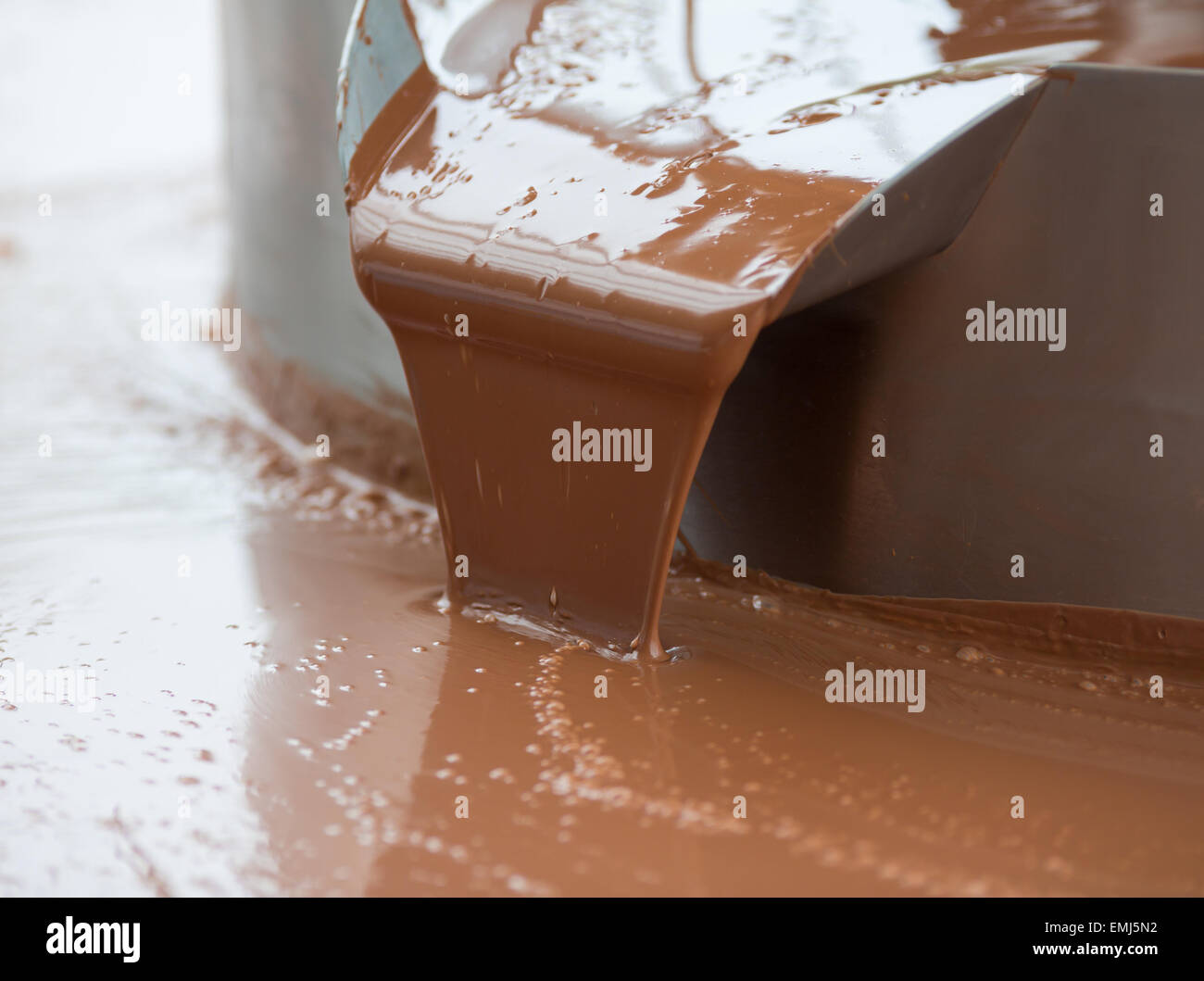 Heiße Milchschokolade Flow oder Stream auf Fabrik Stockfoto