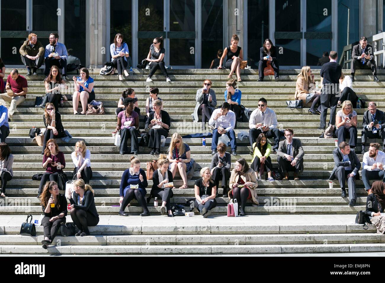 Sonniges Wetter im Stadtzentrum von Manchester heute (Dienstag, 21. April 2015). Mittagessen auf den Stufen des Manchester Crown Court. Stockfoto