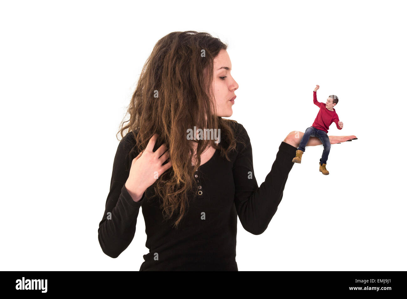 junge Frau kleinen Mann auf der Handfläche halten und bläst Stockfoto