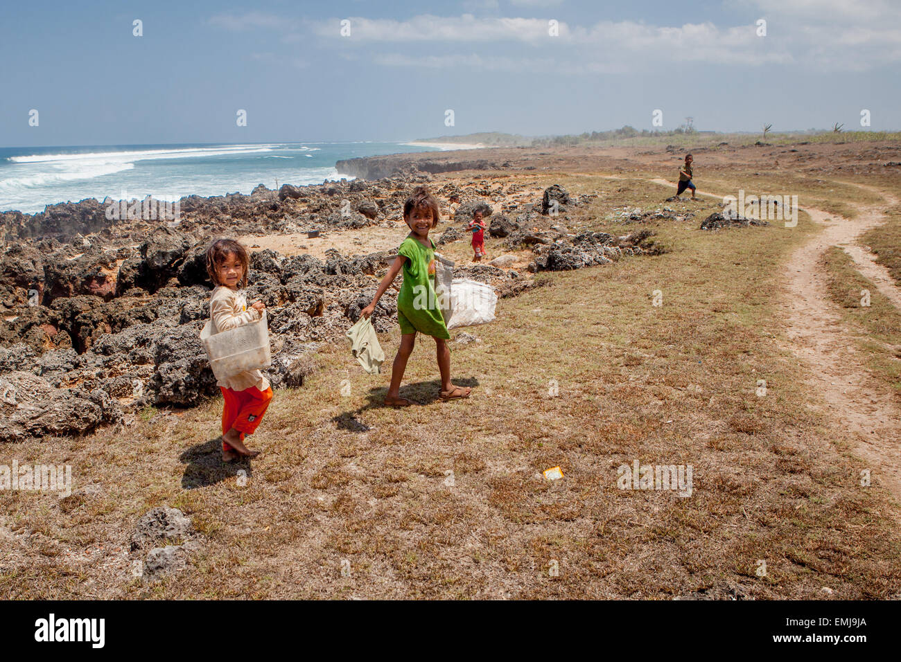 Eine Gruppe von Kindern auf trockenem, felsigen Küstengelände in Pero, Pero Batang, Kodi, Southwest Sumba, East Nusa Tenggara, Indonesien. Stockfoto