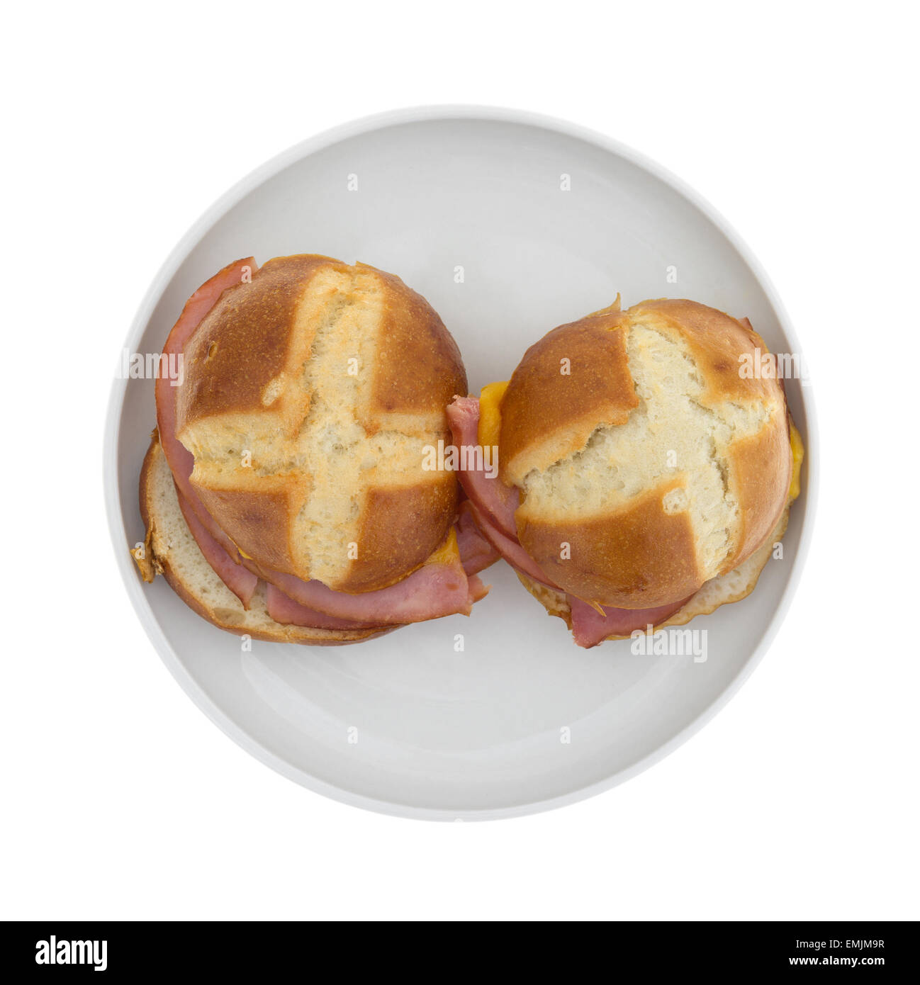 Draufsicht auf zwei sehr kleine Schinken und Käse-Sandwiches auf einer Platte auf einem weißen Hintergrund. Stockfoto