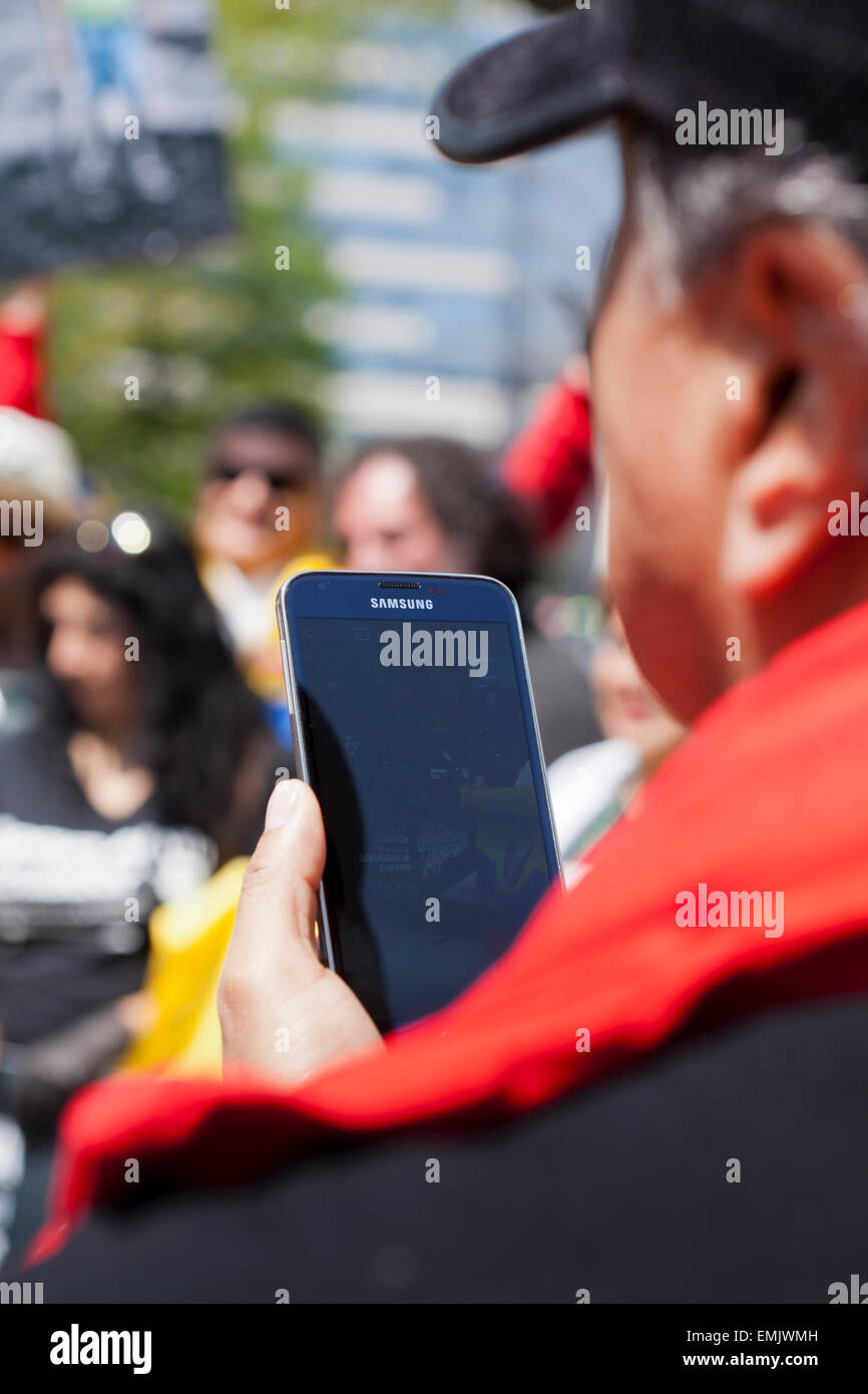 Mann, Blick auf sein Samsung Galaxy Handy - USA Stockfoto