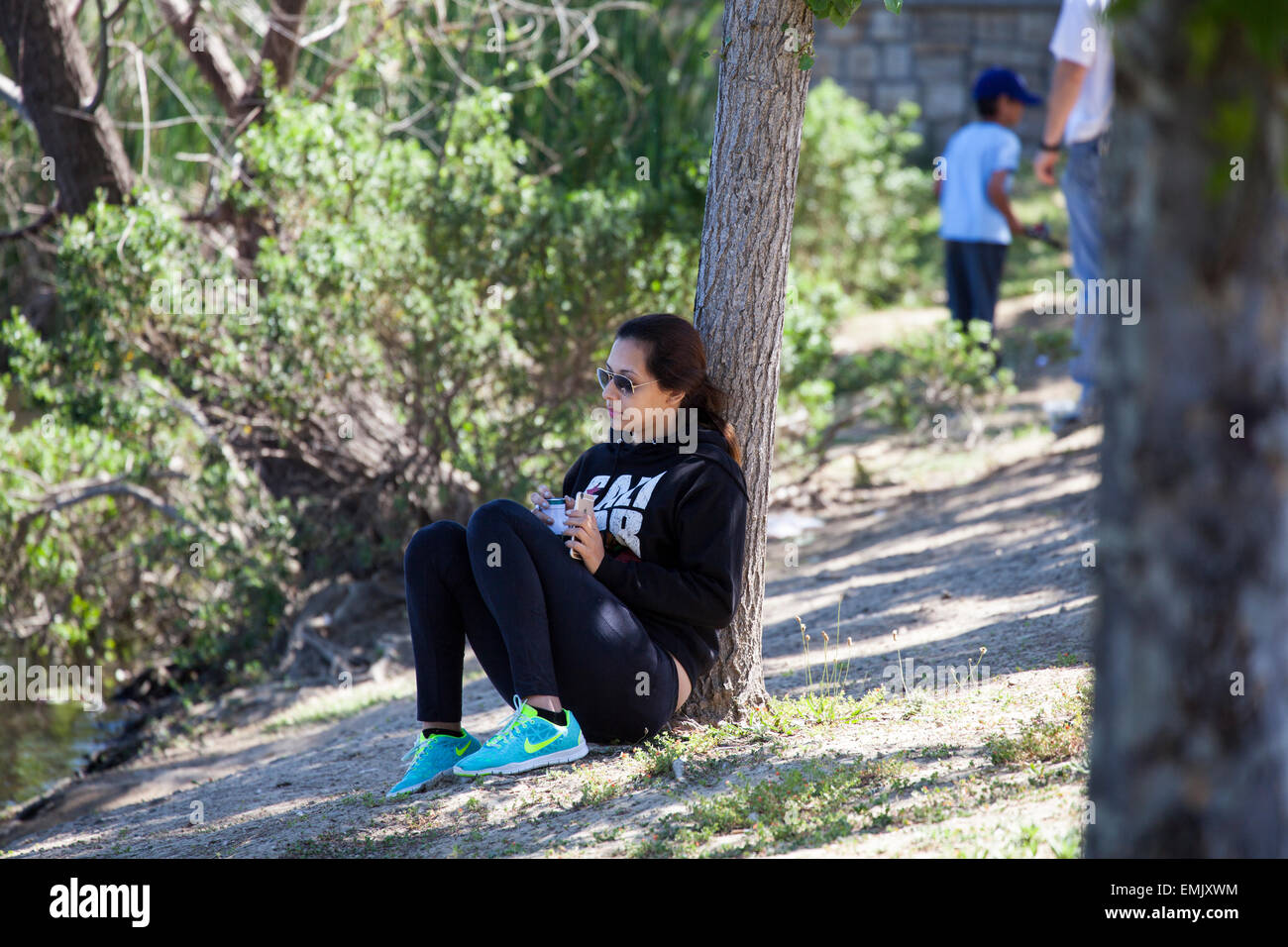 Frau sitzt unter einem Baum, Novato, Marin County, Kalifornien, USA Stockfoto