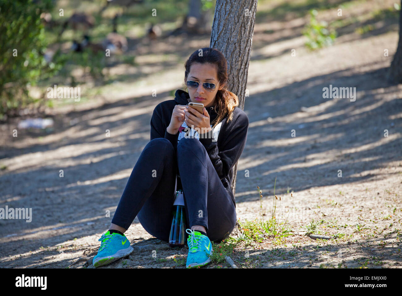Frau SMS in einem Park, Novato, Marin County, Kalifornien, USA Stockfoto