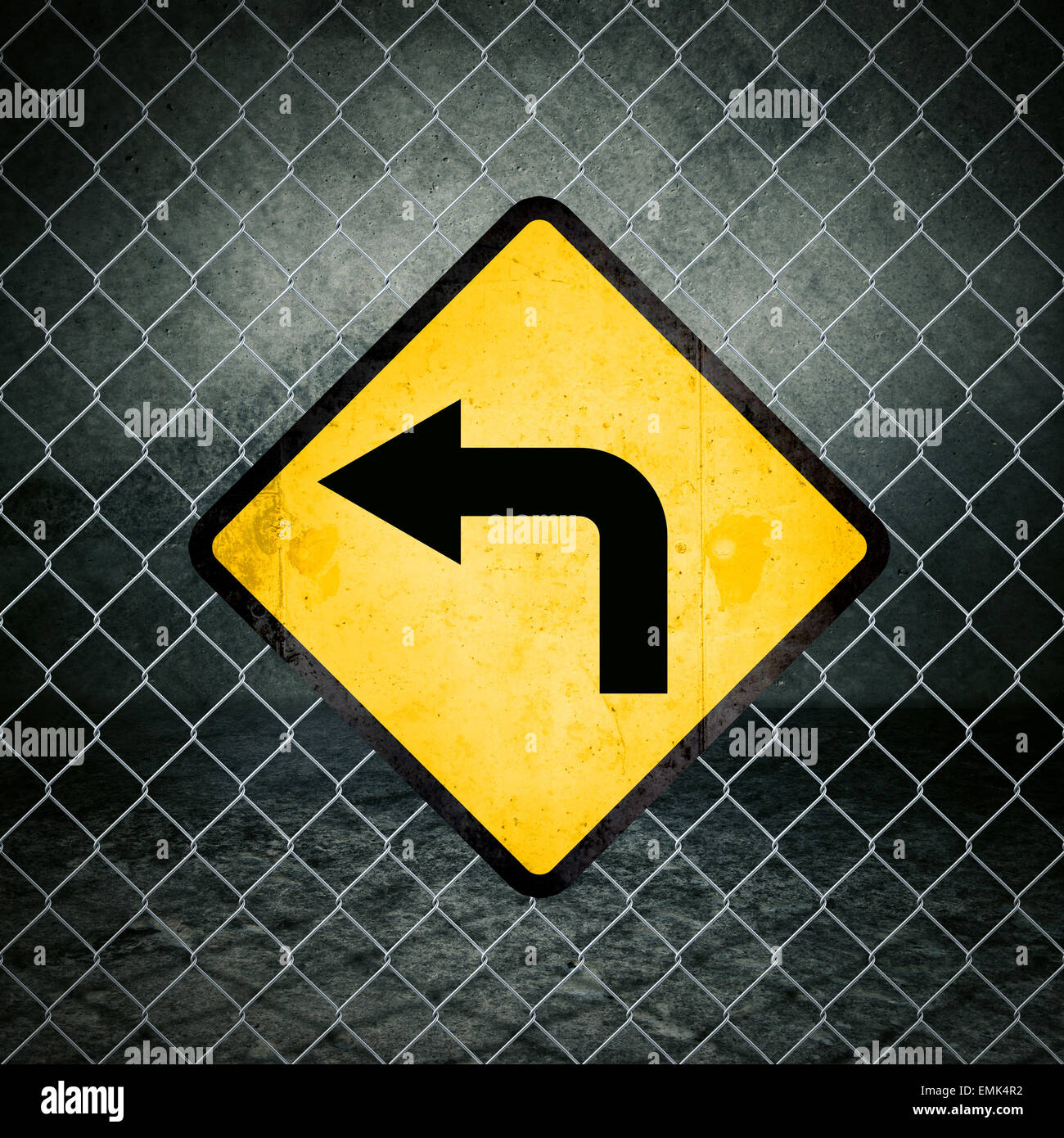 Links Richtung Grunge gelb Warnzeichen auf Maschendrahtzaun der Industriehalle Stockfoto