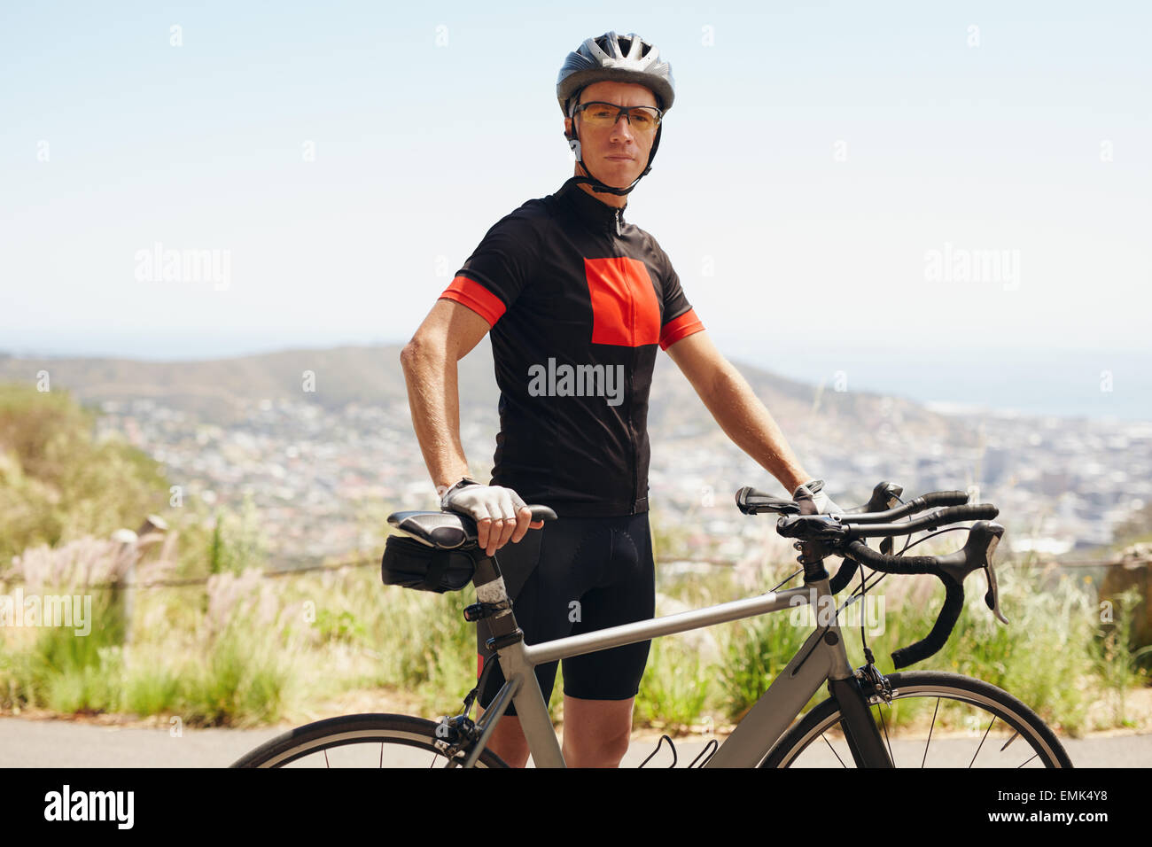 Porträt von Fit junger Mann mit seinem Fahrrad im Freien stehen. Eine Pause nach einem Radsport Training. Stockfoto