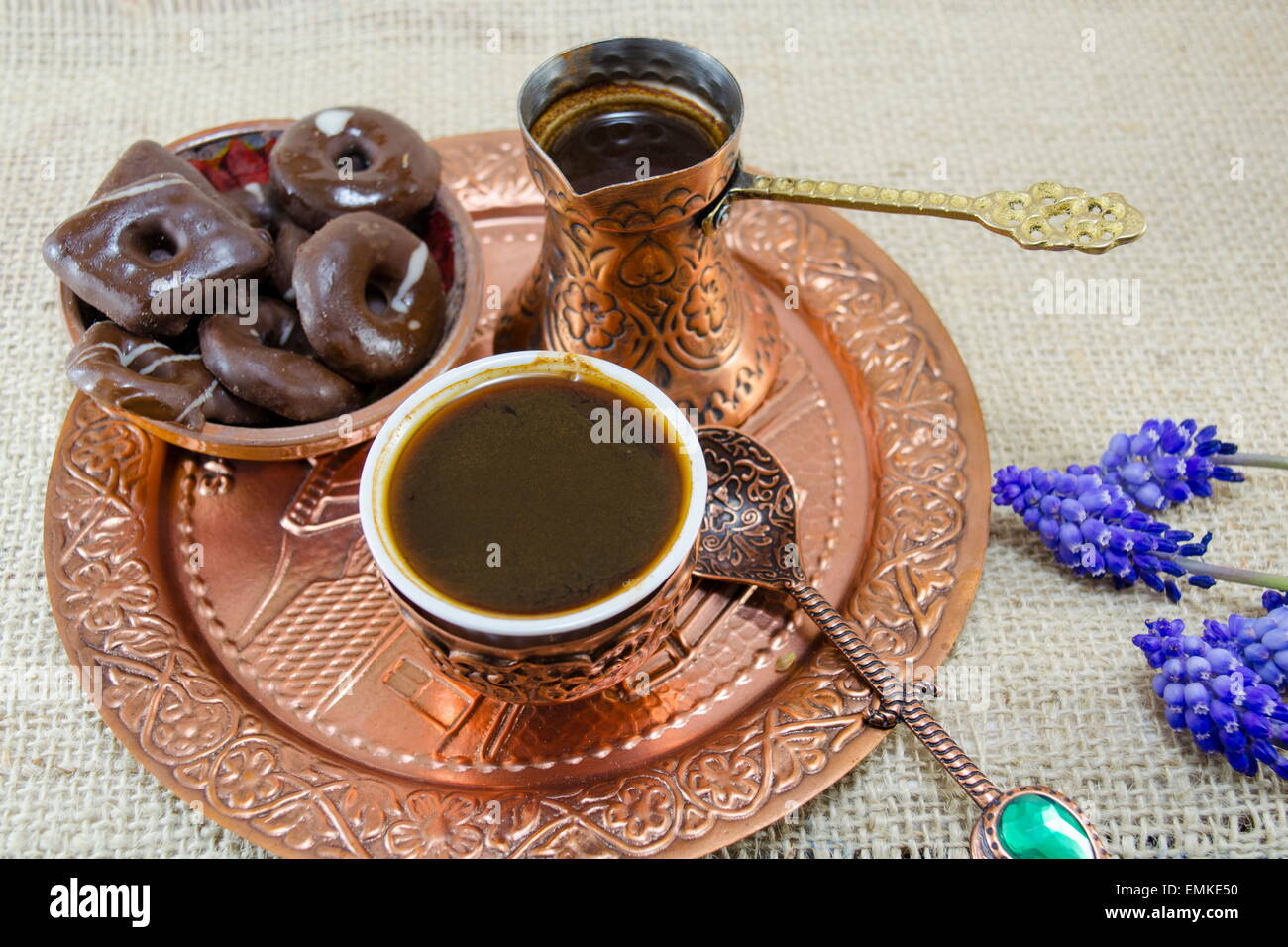 Türkischer Kaffee mit Keksen und Blumen in Kupfer Tassen auf einem Teller Stockfoto