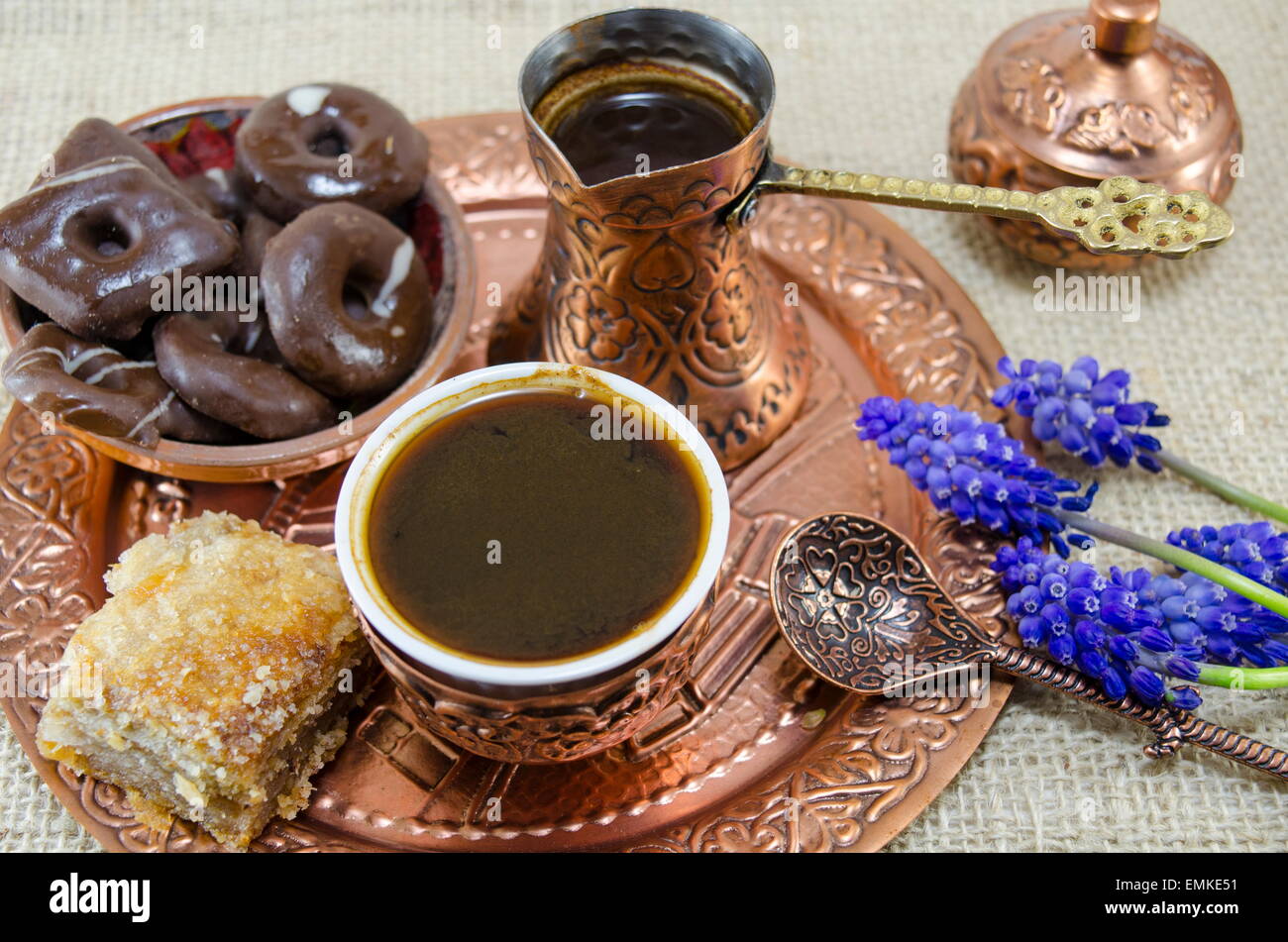 Türkischer Kaffee mit Keksen und Blumen in Kupfer Tassen auf einem Teller Stockfoto