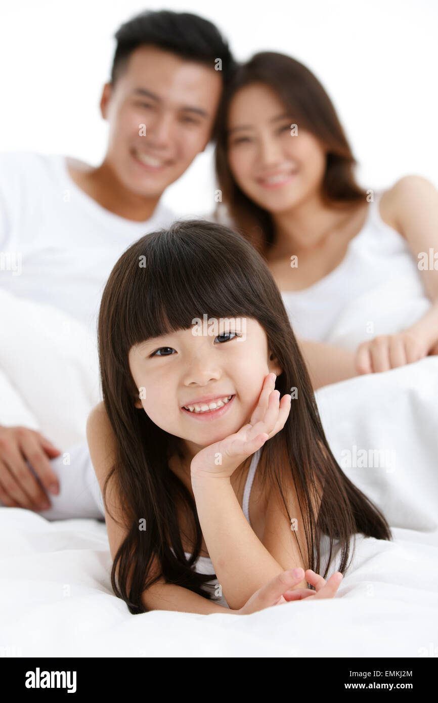 Eine Familie mit drei in das Bett des Schlafzimmers zu spielen Stockfoto