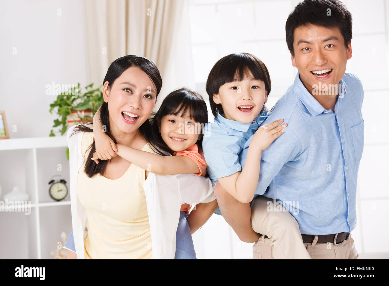 Die Freude, eine vierköpfige Familie im Wohnzimmer Stockfoto