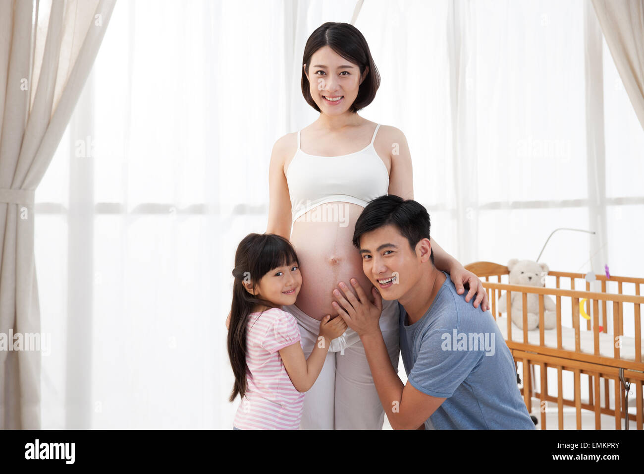 Der junge Vater und Kinder hören den Mutterleib Stockfoto