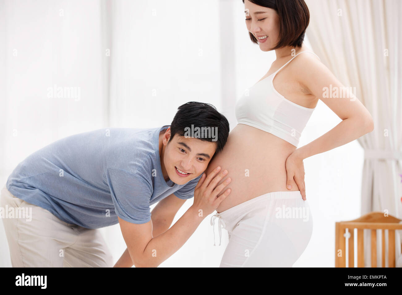 Der junge Vater streichelte schwangeren Bauch des Fötus hören Stockfoto
