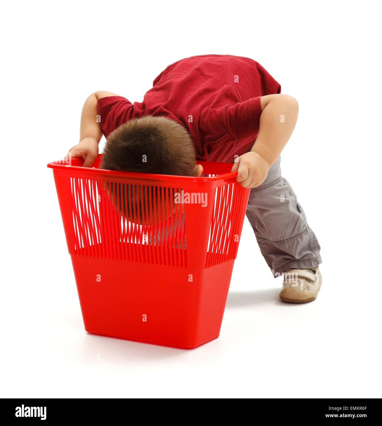Kleiner Junge tiefer Blick ins rote Mülltonne Stockfoto