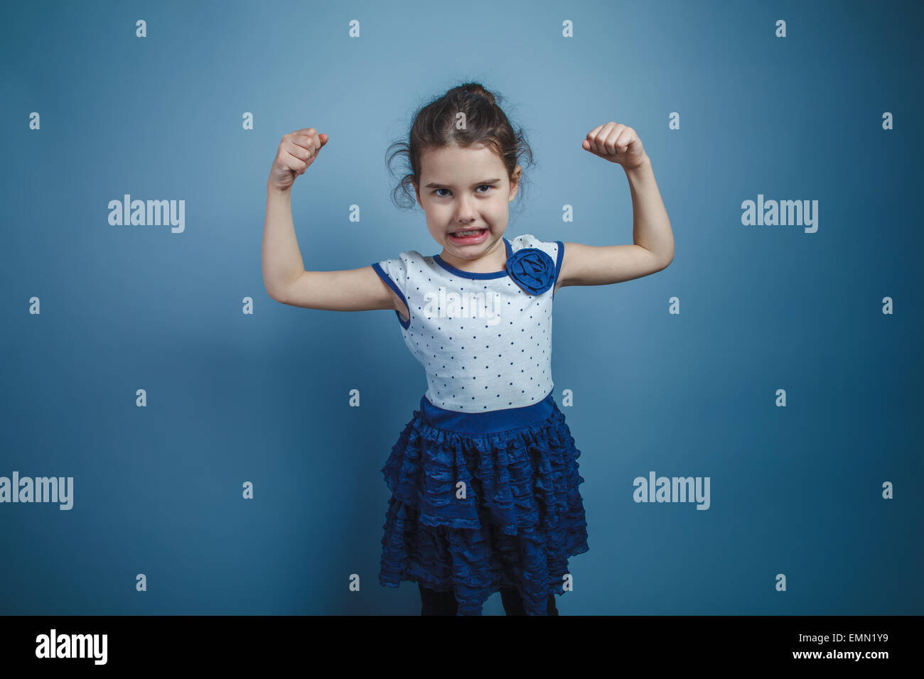 eine Mädchen von sieben europäischen Aussehen Brünette hob ihre Hände oben zeigt Stärke, Kraft Stockfoto