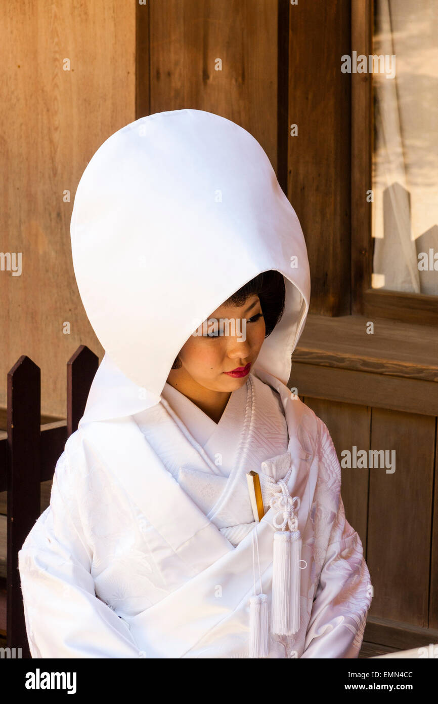 Japan, Nara, Tamukeyama Schrein. Japanische Braut sitzen im traditionellen shiromuku weissen Kimono und Cape Art Hut auf dem Kopf. Stockfoto