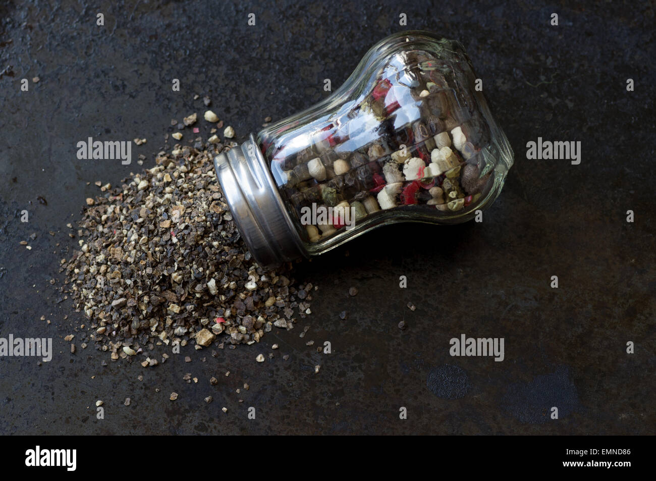 Pfeffermühle mit zerbröselten Pfeffer auf einen schwarzen Hintergrund Draufsicht Stockfoto