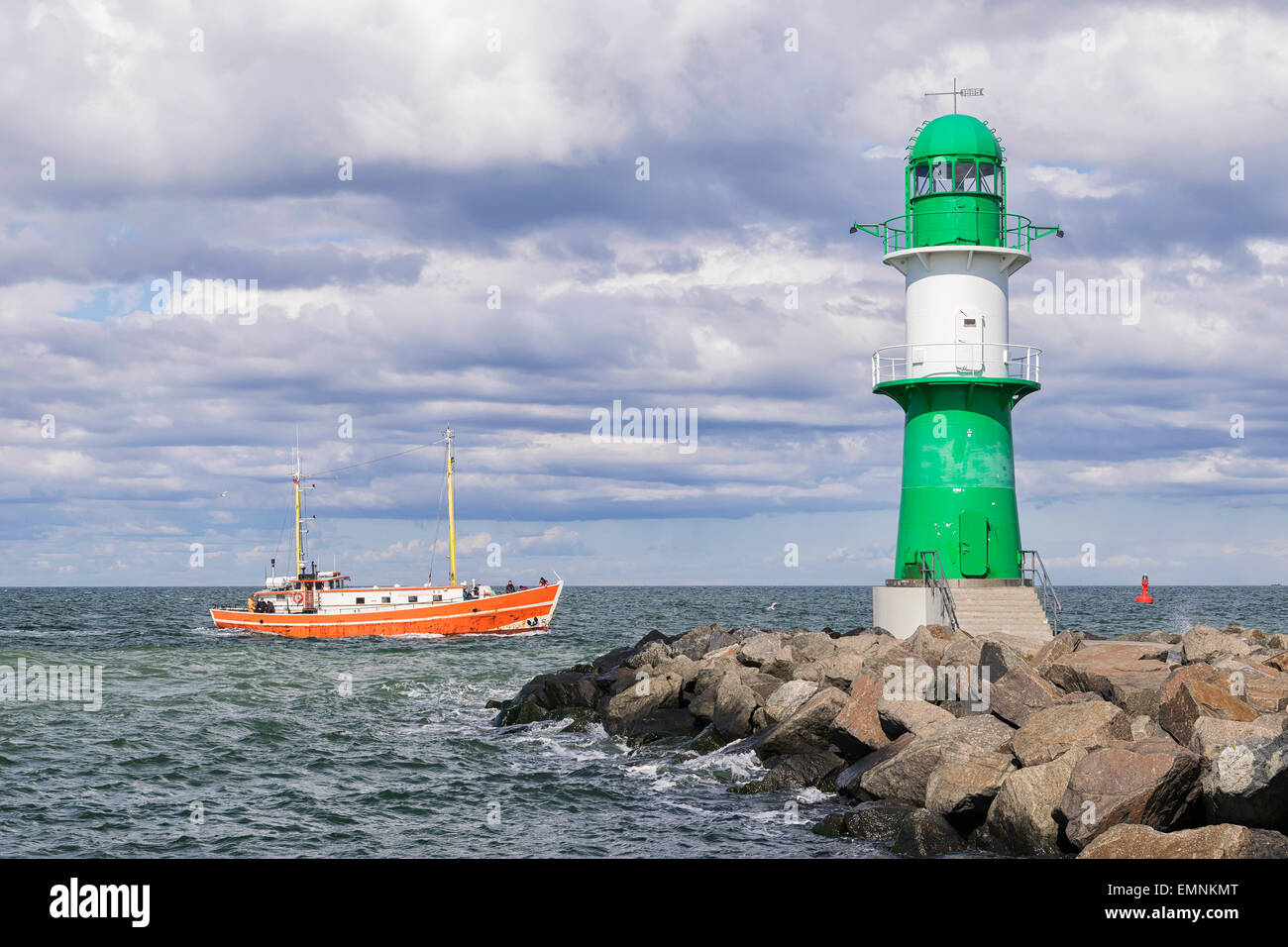 Bild von der Leuchtturm von Warnemünde auf der Ostsee an der Hafeneinfahrt mit Fischerboot, Deutschland Stockfoto