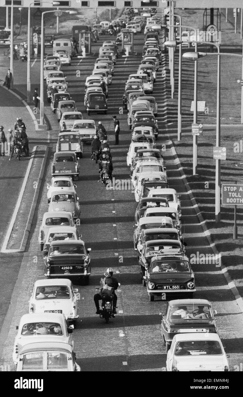 Autofahrer Schlange stehen, um ihre Mautgebühr am Dartford Tunnel zu zahlen, als sie nach Hause zurückkehren nach einem sonnigen Feiertag. 30. Mai 1966. Stockfoto