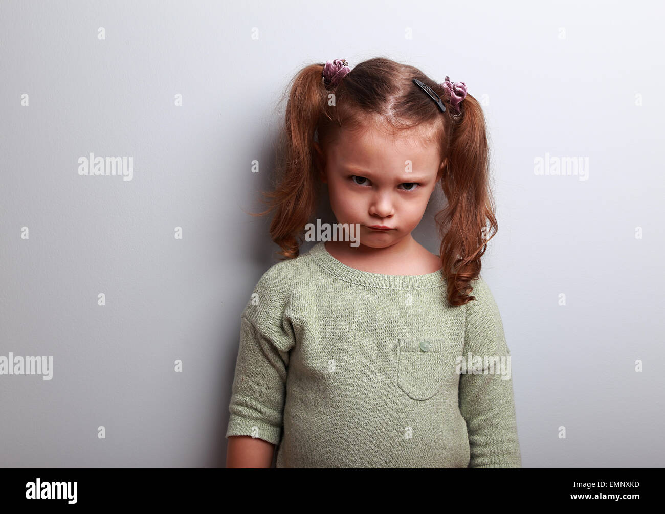 Traurige verlassene Kind Mädchen unglücklich auf blauem Hintergrund Stockfoto
