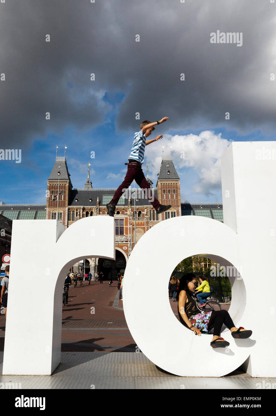 Junge springt auf das I Amsterdam-Logo in Amsterdam Stockfoto