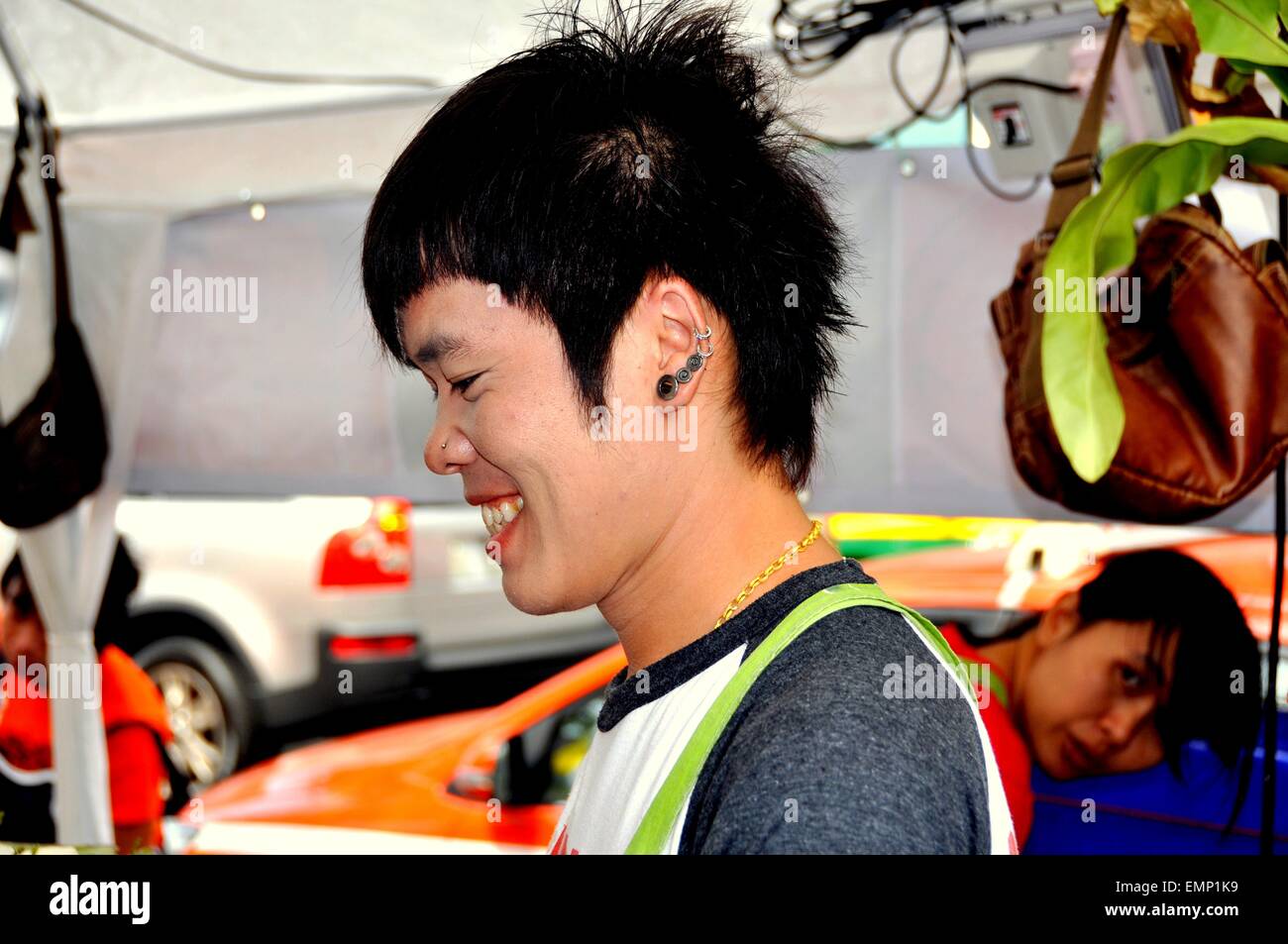 Bangkok, Thailand: Thailändische Jugend mit mehreren Ohrringe und eine Nase piercing Verkauf Lebensmittel an Rama IV Road am San Yan Stockfoto