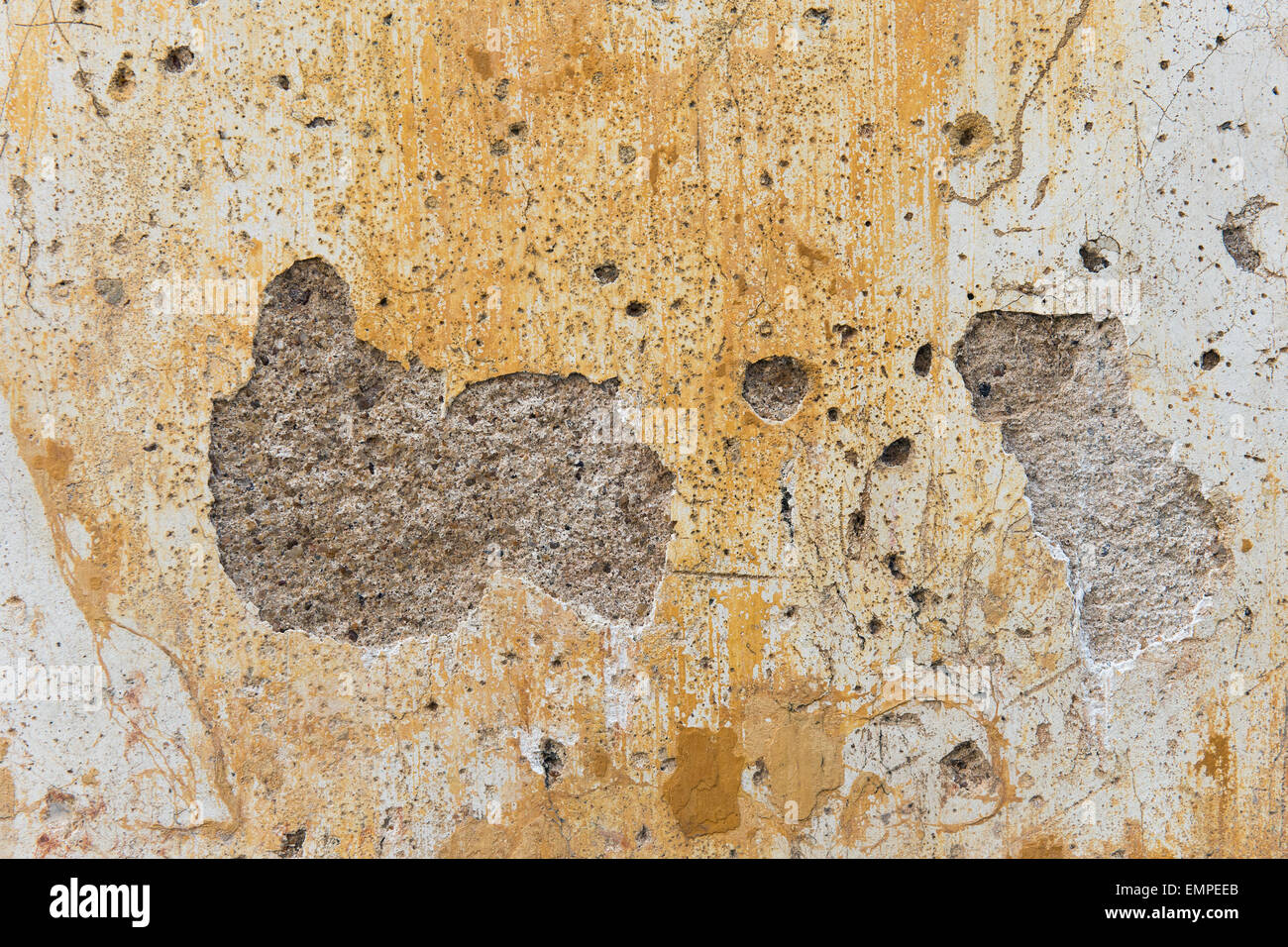Wand mit Löchern, Gips und Spuren von gelber Farbe, Kerala, Indien Stockfoto