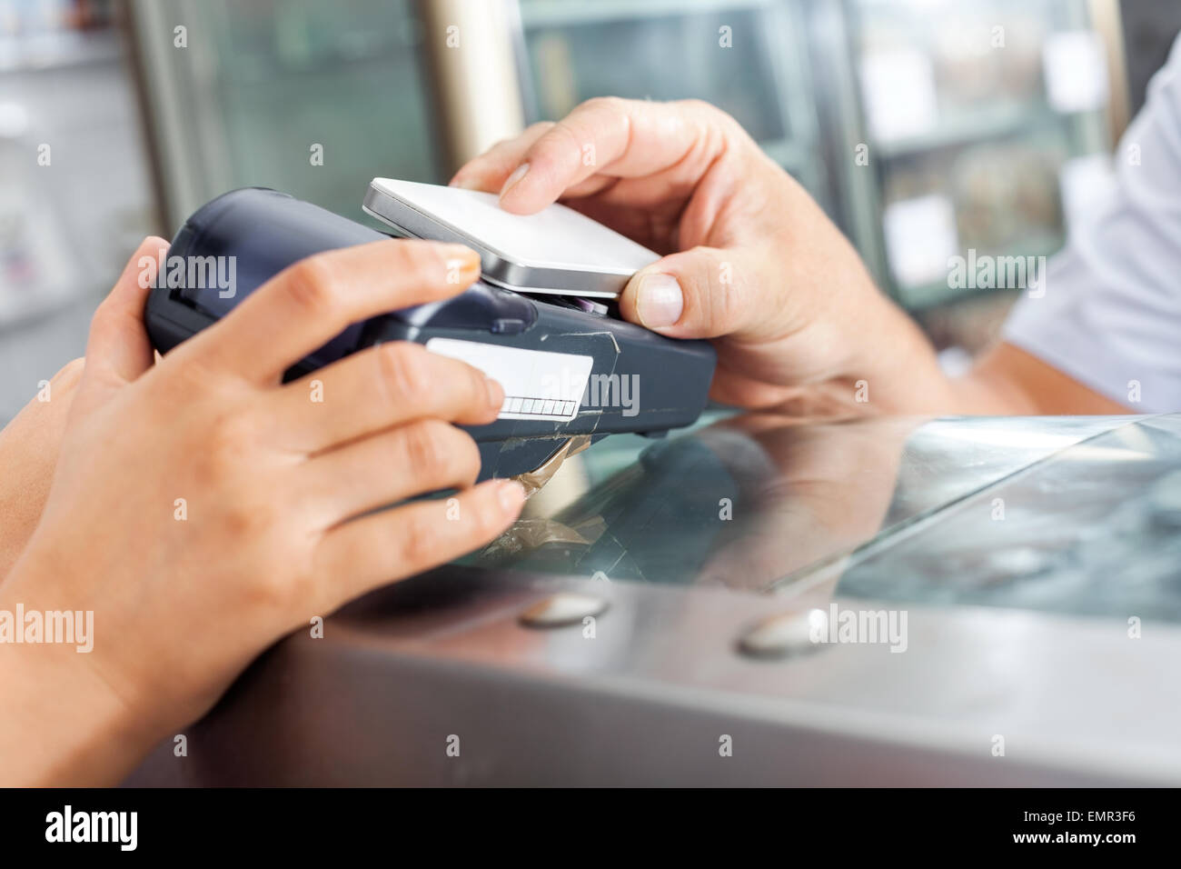 Kunden die Zahlung durch Smartphone in Metzgerei Stockfoto