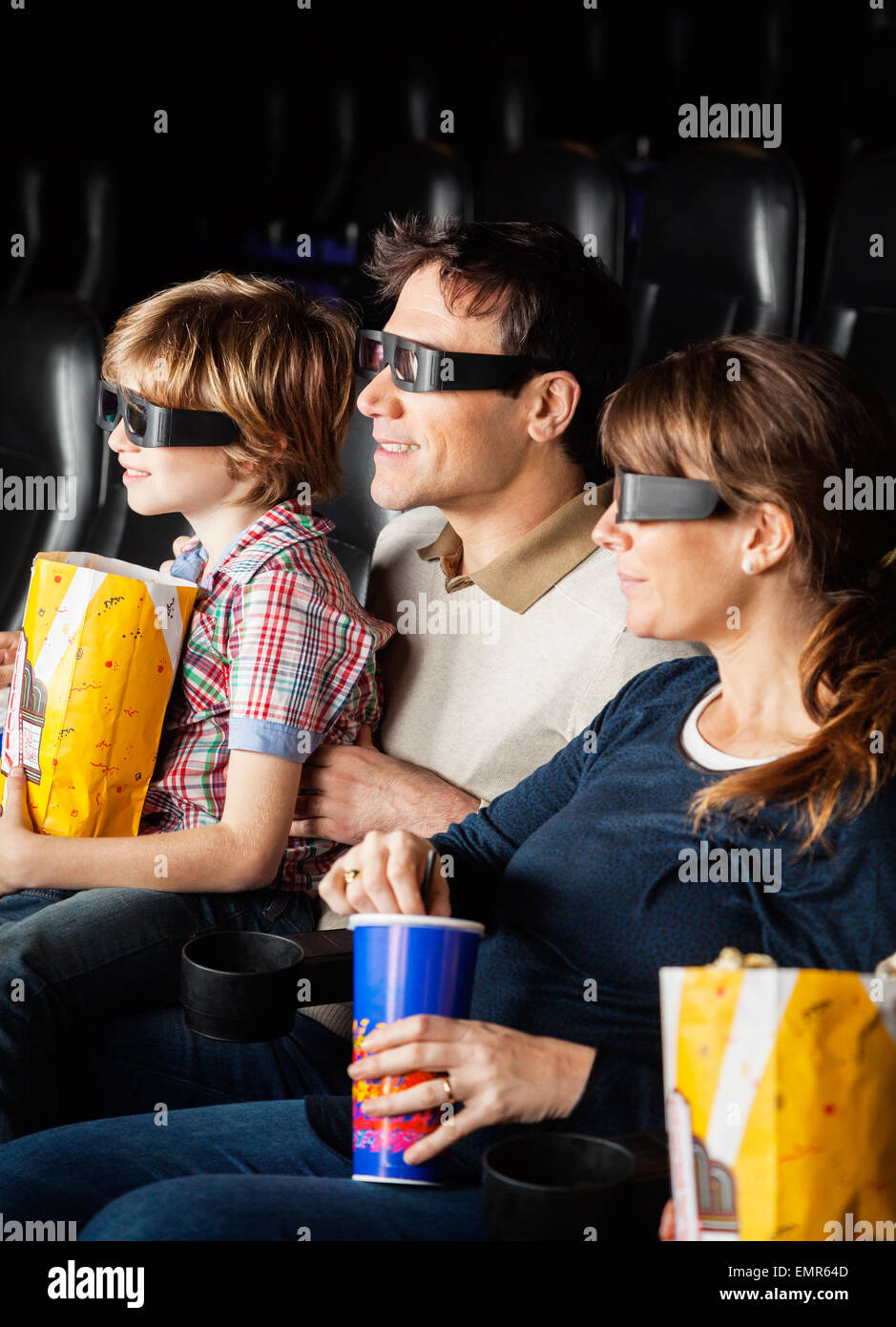 Familie mit Snacks bei 3D Film Stockfoto