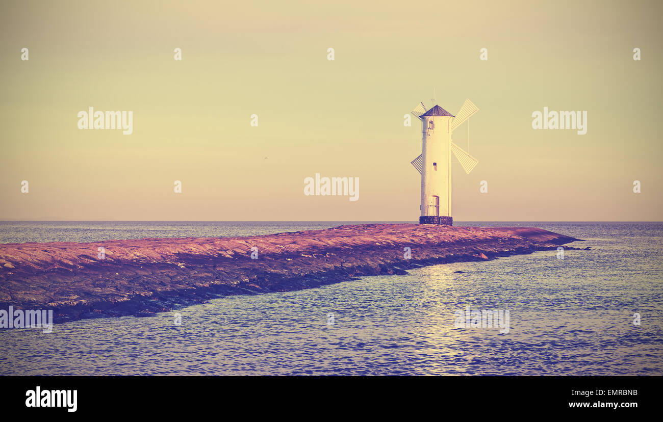 Retro Vintage stilisierte Sonnenaufgang über Ostseeküste, Leuchtturm in Swinoujscie, Polen. Stockfoto
