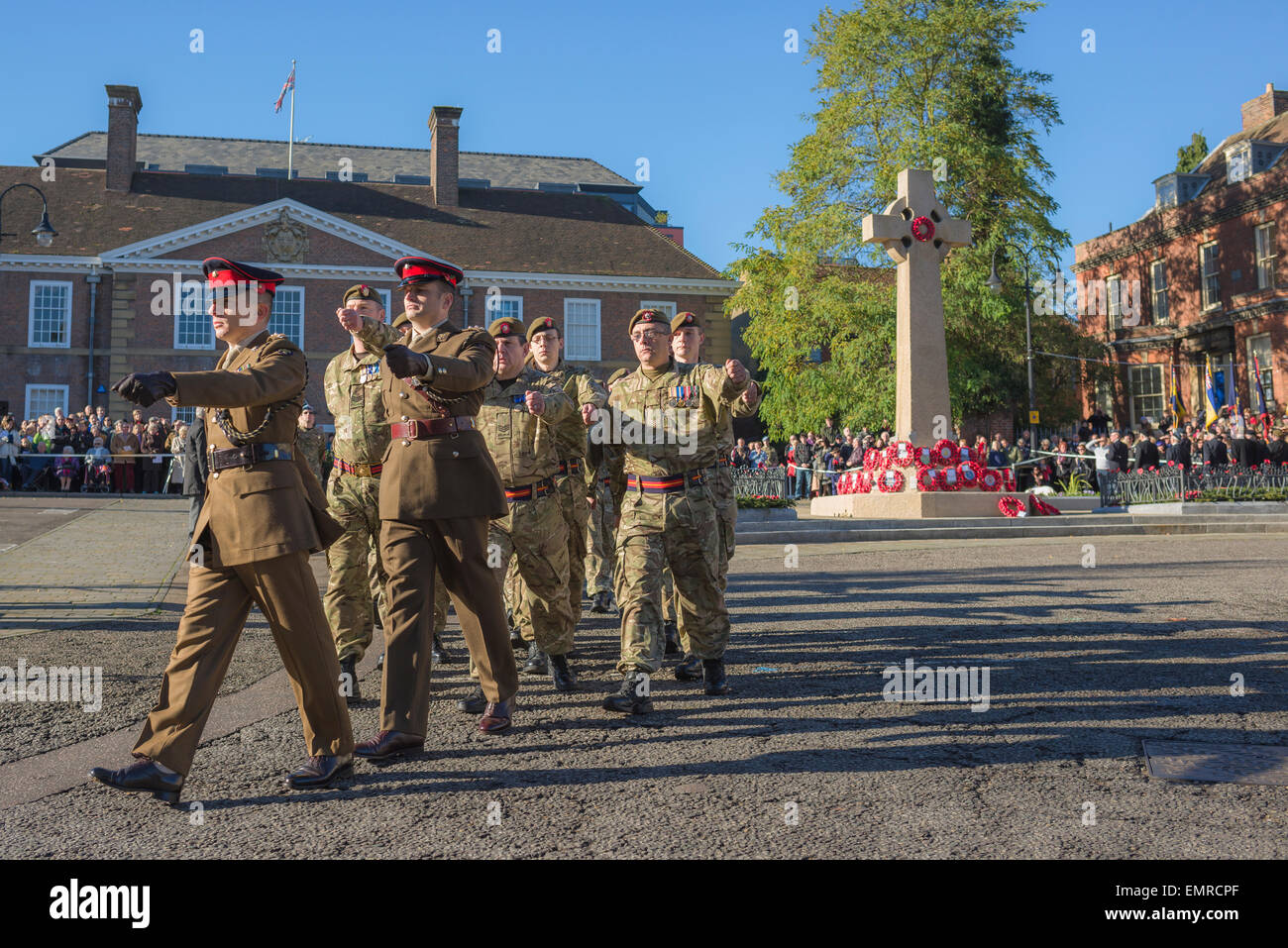 Soldaten marschieren in Großbritannien, am Gedenktag marschieren eine Gruppe Soldaten an einem Kriegsdenkmal-Kreuz auf dem Angel Hill in Bury St Edmunds, Suffolk, Großbritannien, vorbei Stockfoto