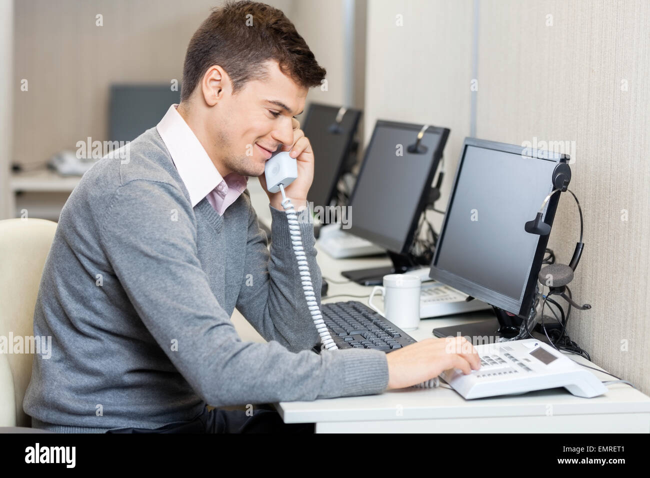 Call-Center Mitarbeiter mit Festnetz-Telefon Stockfoto