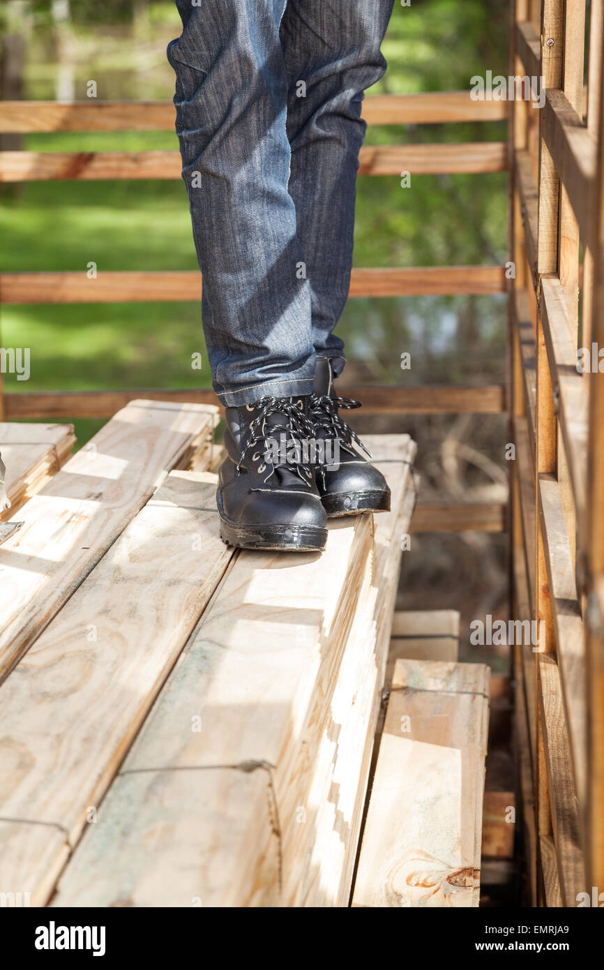 Bauarbeiter auf gestapelten Holzbohlen Stockfoto