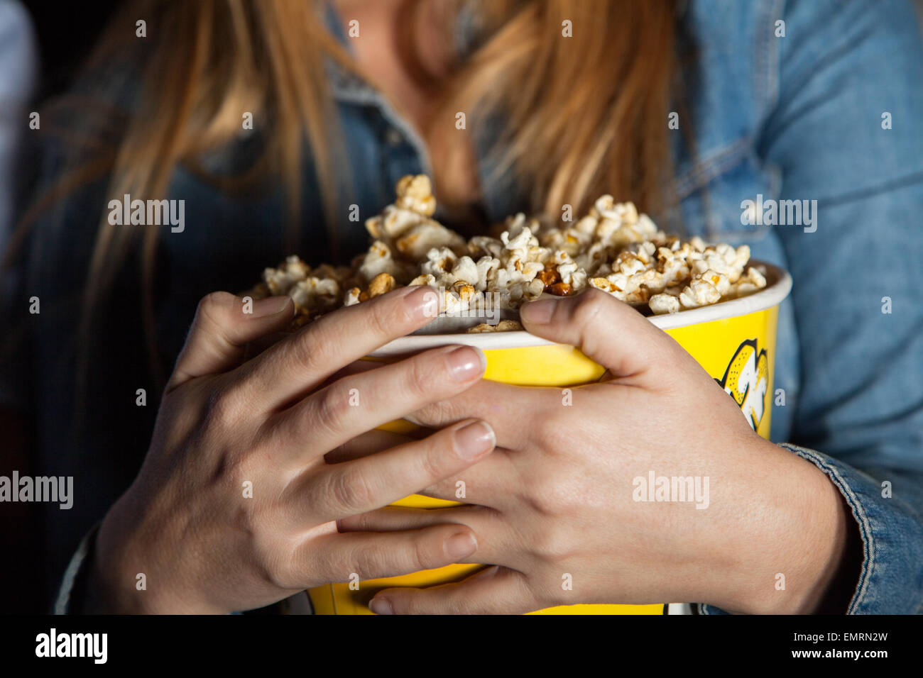 Frau mit Popcorn Eimer im Theater Stockfoto