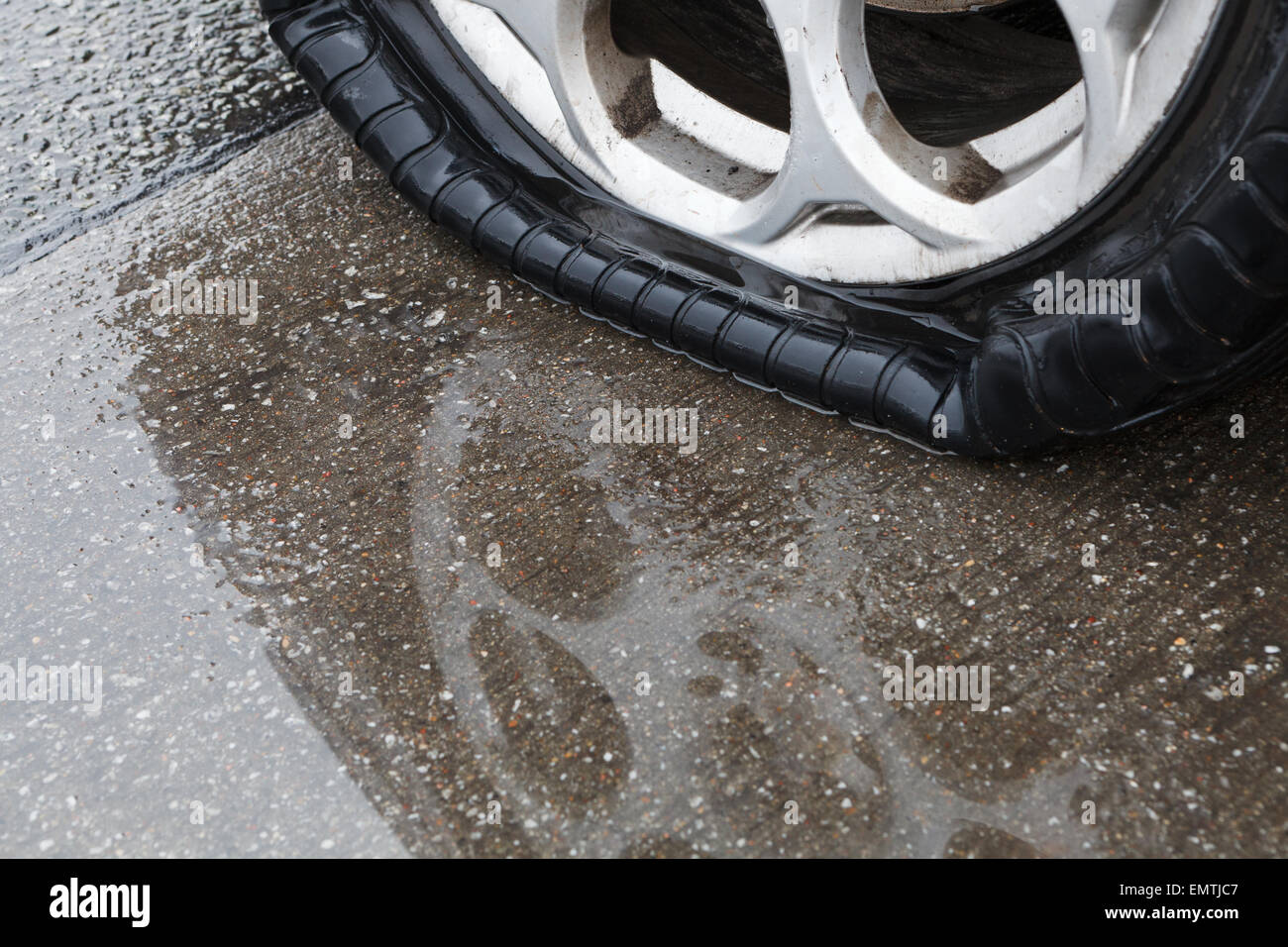 Reifenpanne auf nasser Fahrbahn Stockfoto