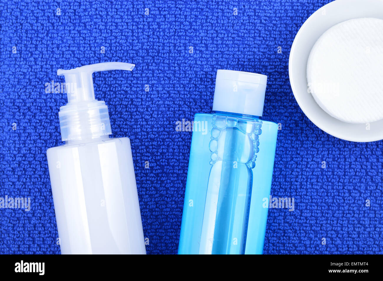 Tägliche Reinigung Kosmetik - Gesicht waschen Reinigungsgel, Glättung, Toner und Reinigung-Pads auf Marineblau Handtuch Baumwolle. Stockfoto