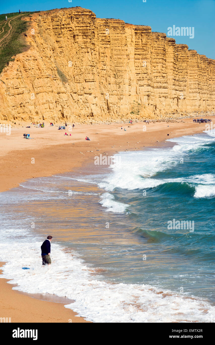 Mann, Paddeln im Meer in West Bay Beach, Dorset, UK. Stockfoto