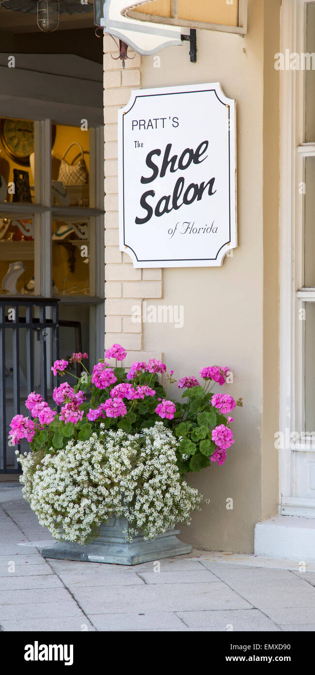 Schuh-Salon-Zeichen und Eingang mit rosa und weißen Blüten Stockfoto