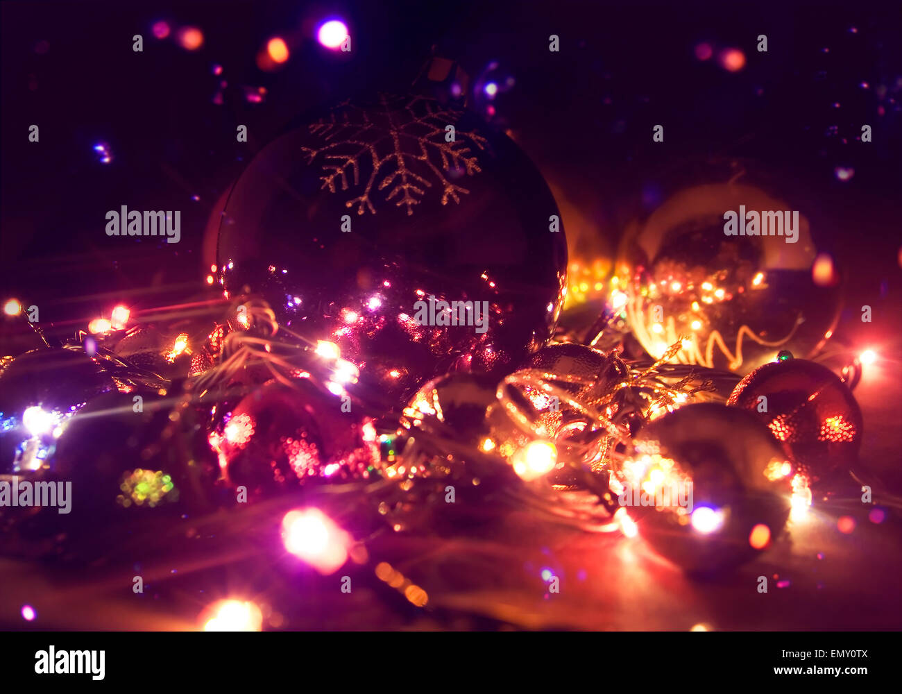 Mehrfarbige Closeup Weihnachtskugeln und elektrische Girlande Zusammensetzung. Stockfoto