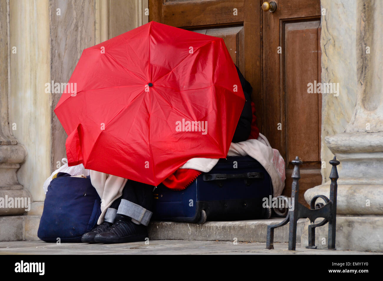 Obdachloser in der Stadt schlafen unter Dach auf Koffer mit persönlichen Habseligkeiten Stockfoto