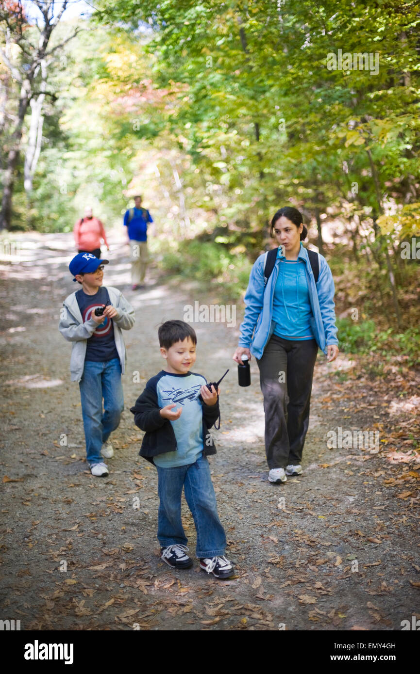 Hispanische Mutter und Kinder (jungen Alter 9 und 5 Spaziergang durch den Wald, wie sie mit ihren Walkie-Talkies spielen. Stockfoto