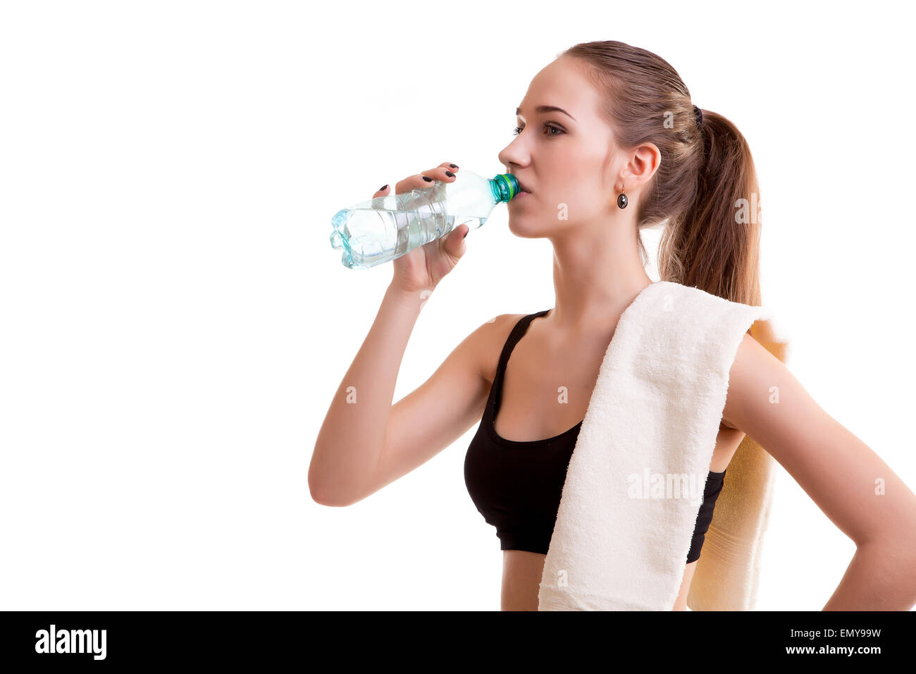 Frau nach Sport Trinkwasser aus der Flasche mit Handtuch auf Schulter isoliert auf weißem Hintergrund Stockfoto
