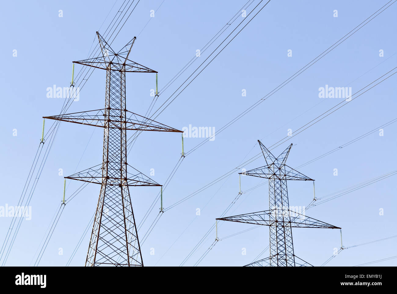 Zwei Stahl-Hochspannungs-Freileitungen und klaren, blauen Himmel Stockfoto